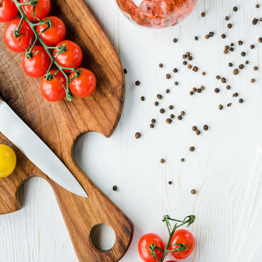black pepper on tomatoes on cutting board