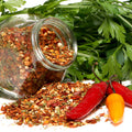 cajun spice blend in jar with peppers and greenery in the back